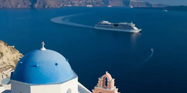Cruise ship sailing along a Mediterranean coast