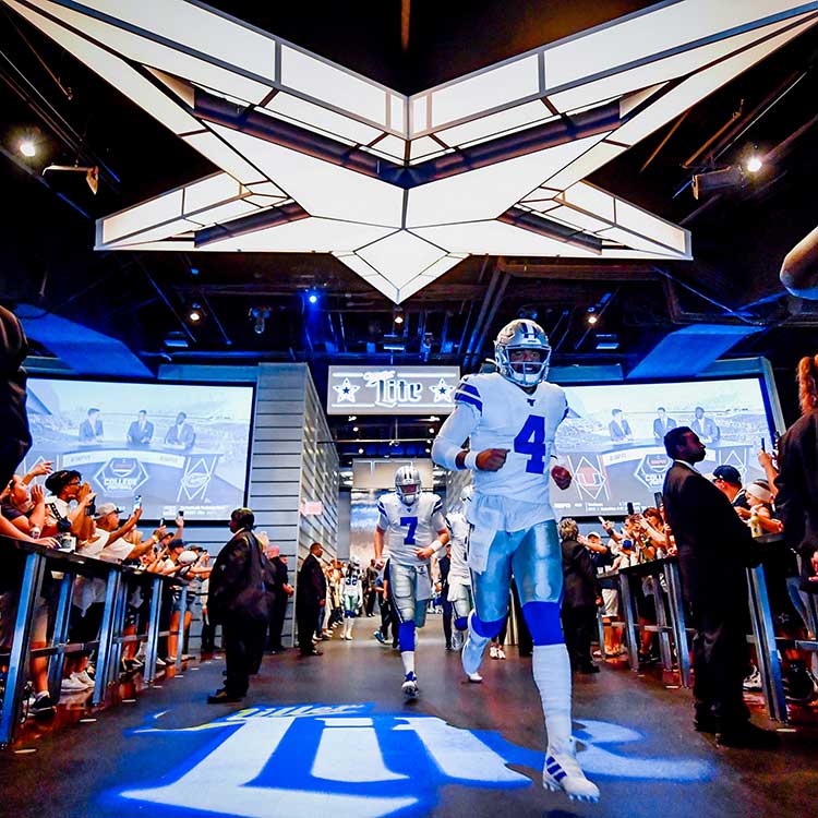 Cowboys players entering the field at AT&T Stadium