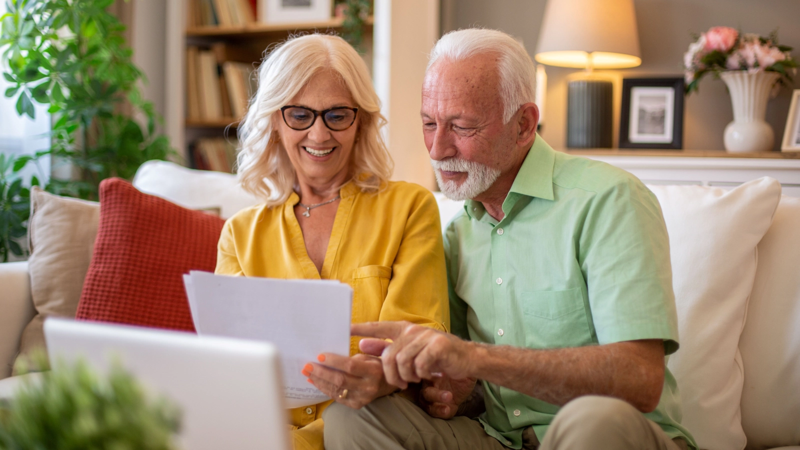 Couple reviewing travel insurance documents on a sofa