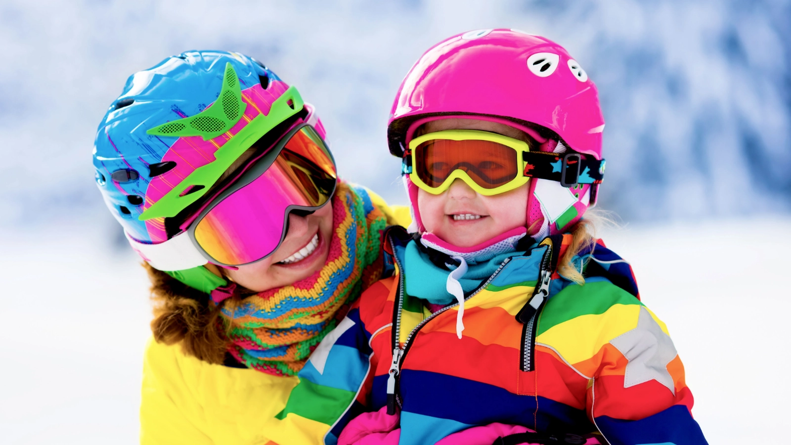 Two people in colourful ski clothing in snowy mountains