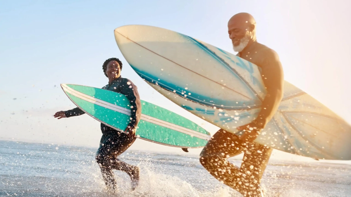 Mature couple enjoying a surfing holiday on a beach