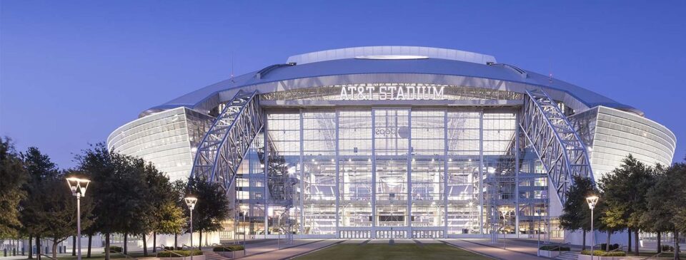AT&T Stadium exterior glowing at dusk