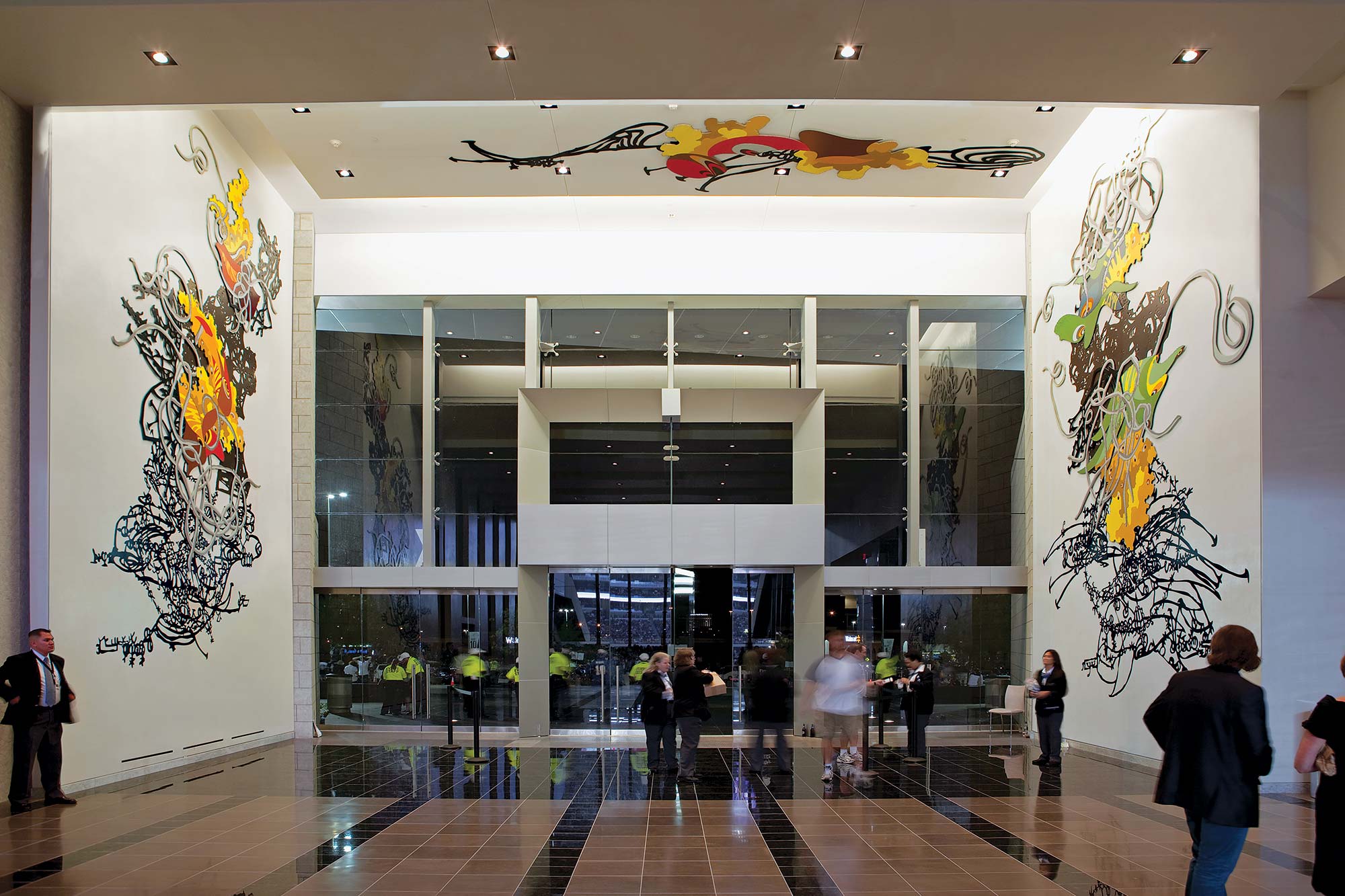 Visitors and colorful artwork in an AT&T Stadium lobby