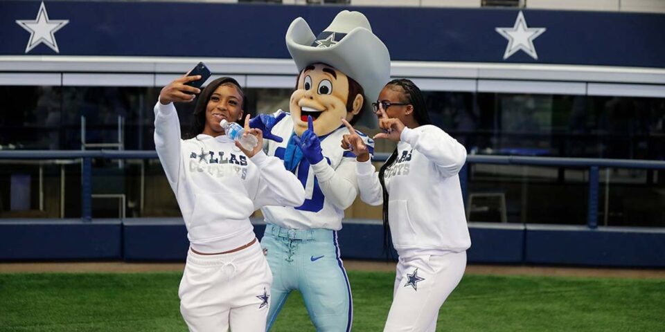 Fans taking a selfie with the Dallas Cowboys mascot inside AT&T Stadium