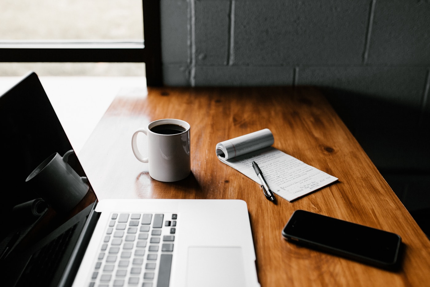 Espace de travail avec ordinateur, carnet et téléphone