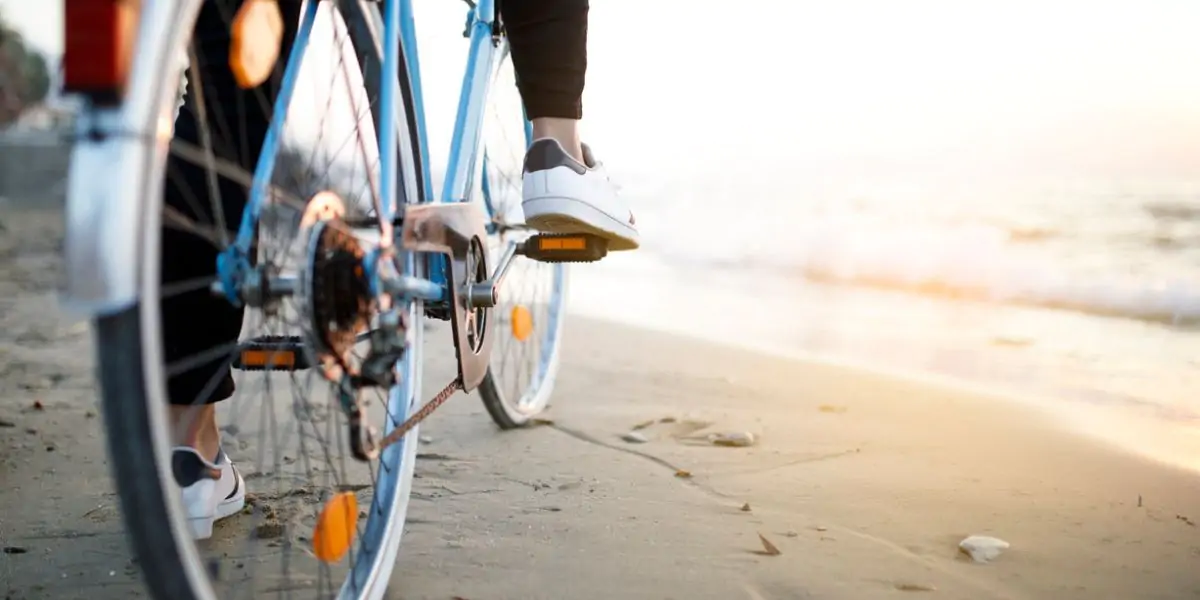 Cyclists riding along a beach on holiday