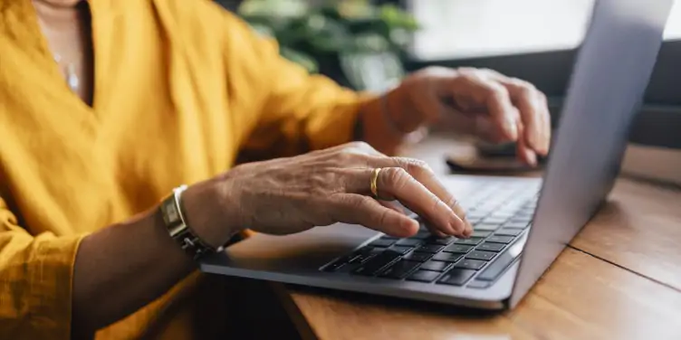 Hands typing on a laptop during travel planning