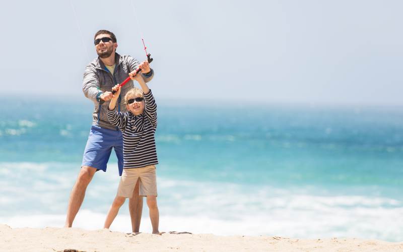 Adulto e bambino che fanno volare un aquilone all'aperto