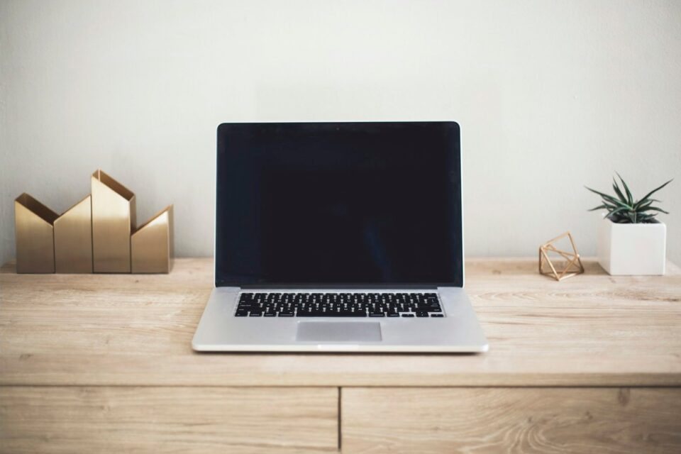 Laptop and desktop workspace on a wooden desk