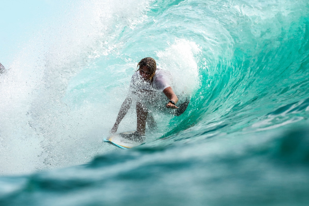 Surfer riding a wave in clear blue water
