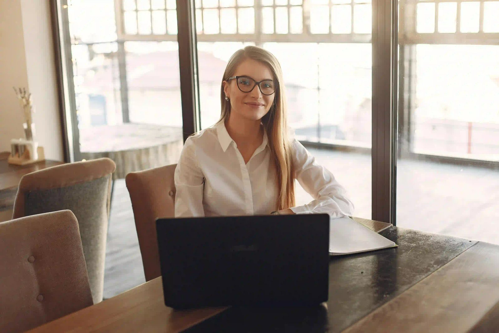 Kvinna sittande bakom laptop i en arbetsmiljö