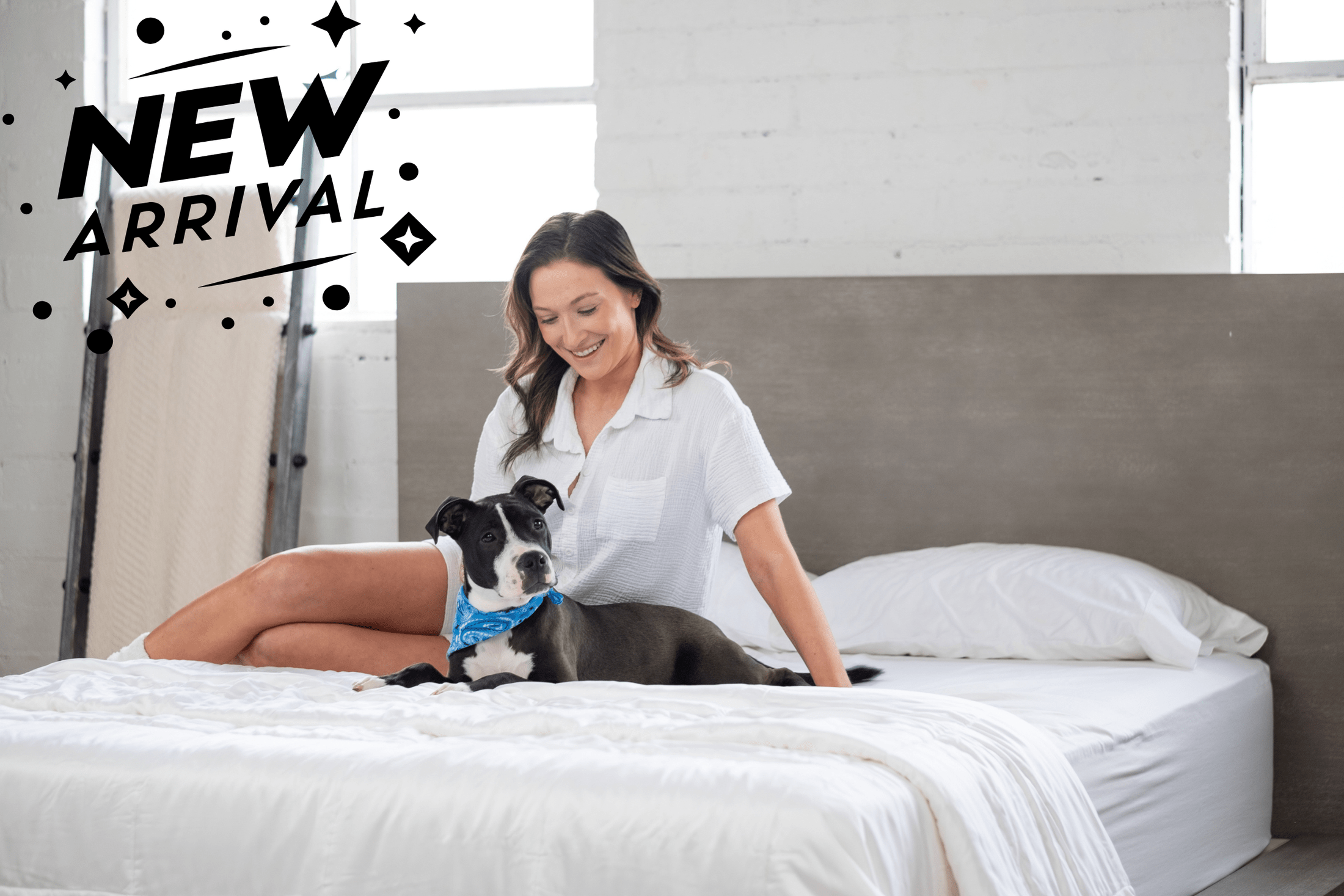 Woman resting with a dog on a neatly made bed