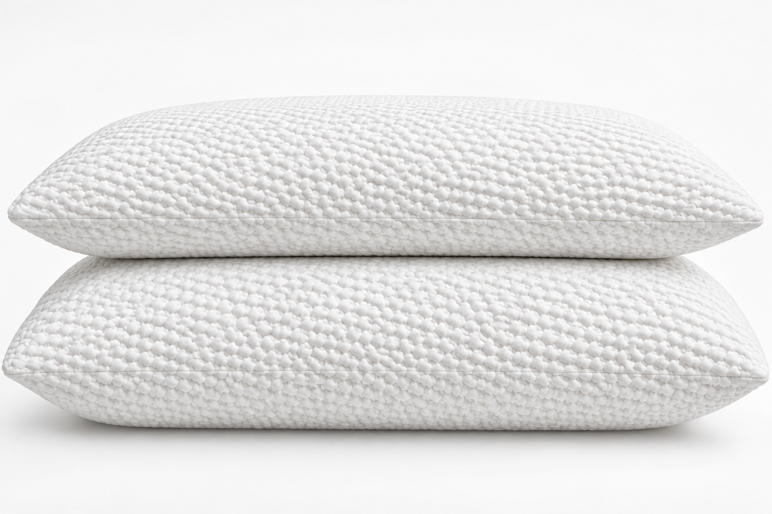 Two white latex pillows stacked on white bedding