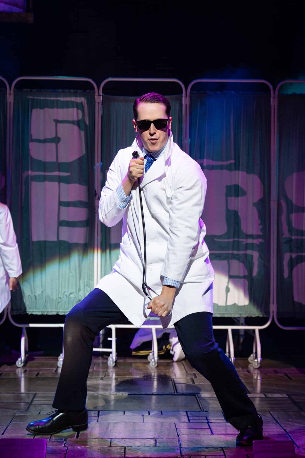 Matilda The Musical performer in a white coat on stage