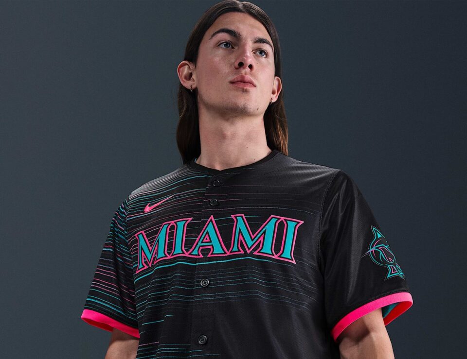 Model wearing a black Miami Marlins City Connect Nike jersey with pink and teal details