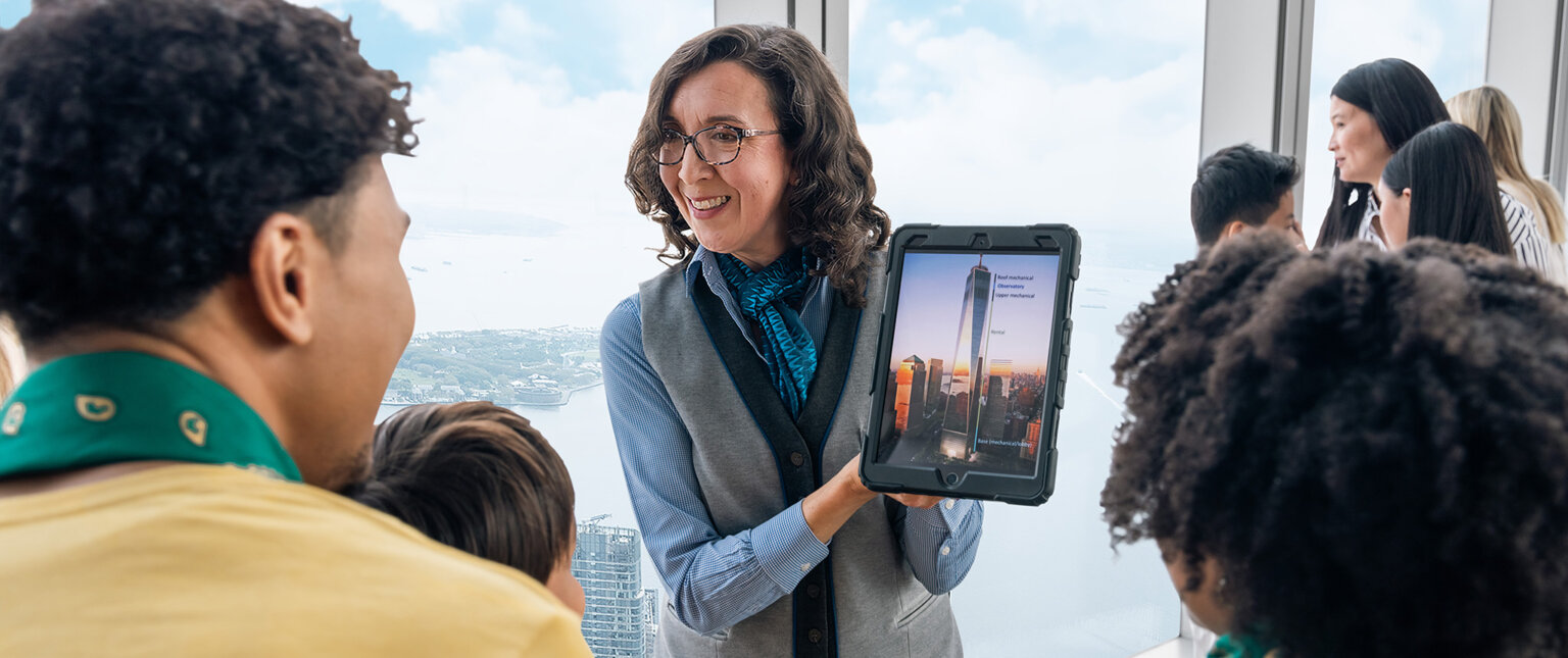 A visitor using the interactive city guide beside the New York skyline at One World Observatory - New York