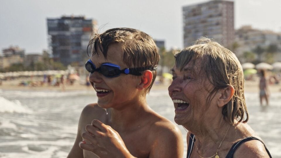 Grandmother and grandson laughing together in the water
