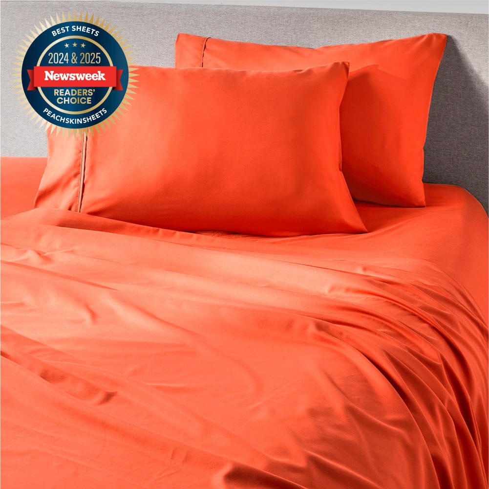 Hot Coral sheet set styled on a made bed