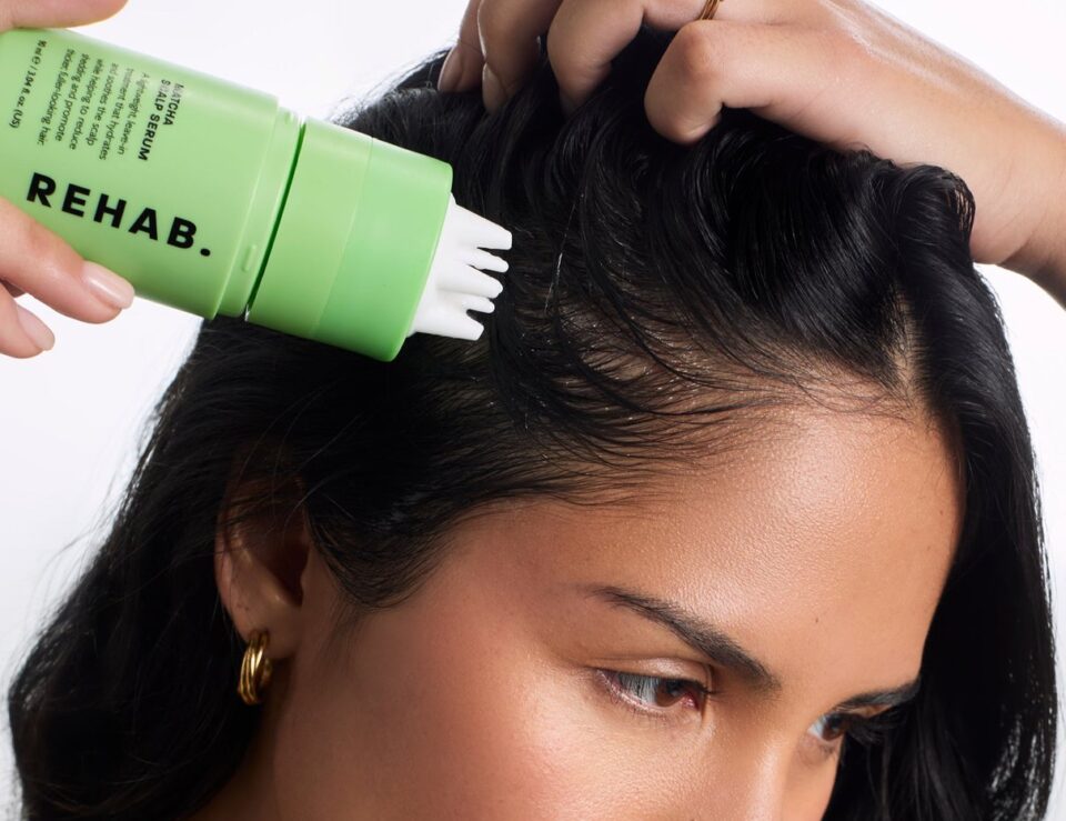 Model applying REHAB Your Hair Matcha Scalp Serum to the scalp