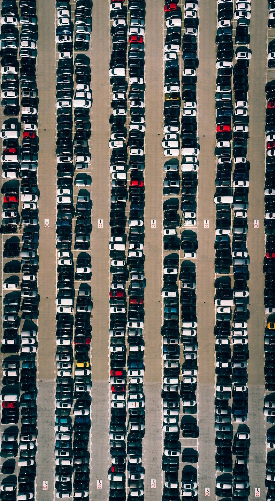 Rows of cars seen from above in a large parking lot