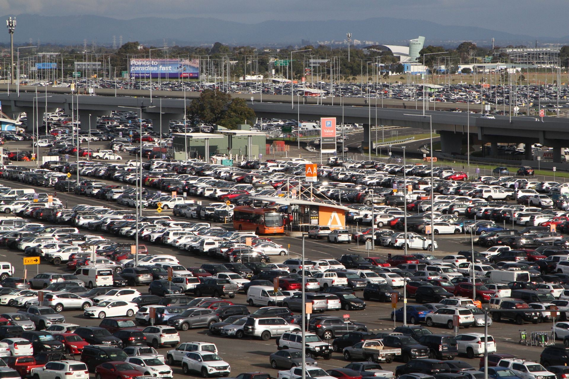 Orange airport shuttle bus in a long-term car park