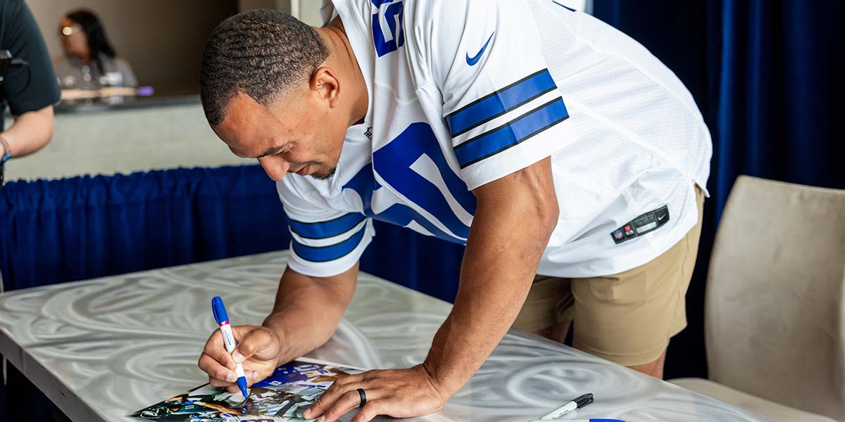 Dallas Cowboys Cheerleaders signing memorabilia during a Rally Day