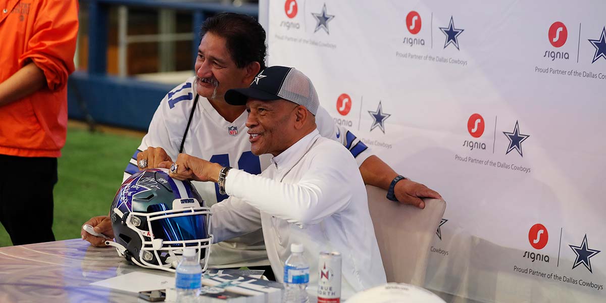 Visitors gathered with a Dallas Cowboys player at a Rally Day event
