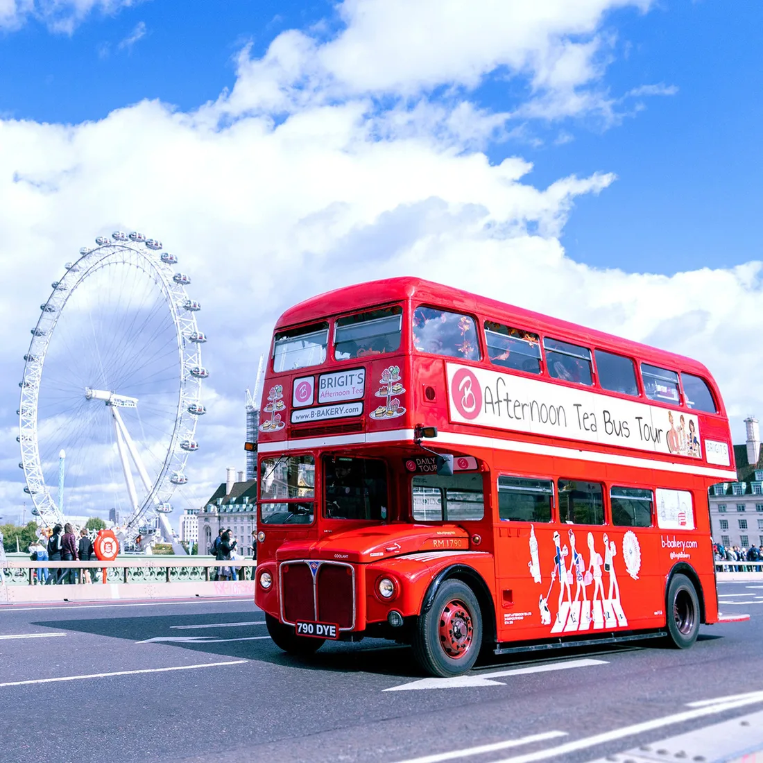 Red sightseeing bus passing the London Eye