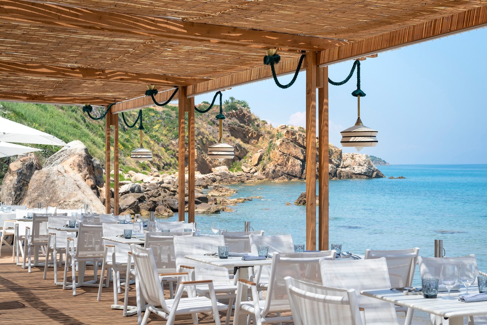Outdoor tables at Riva Beach beside the sea