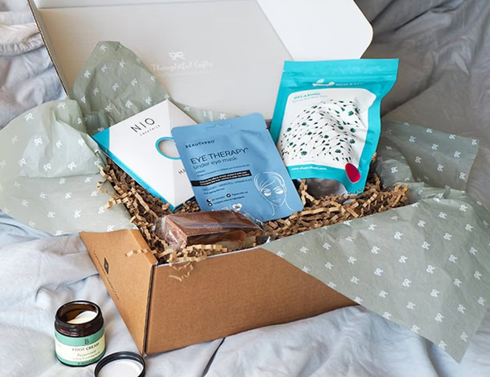 A relaxing gift box arranged on a bed in a lifestyle scene