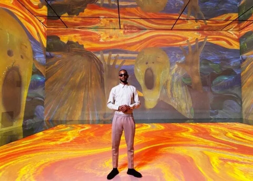 Visitors surrounded by projected art at Frameless