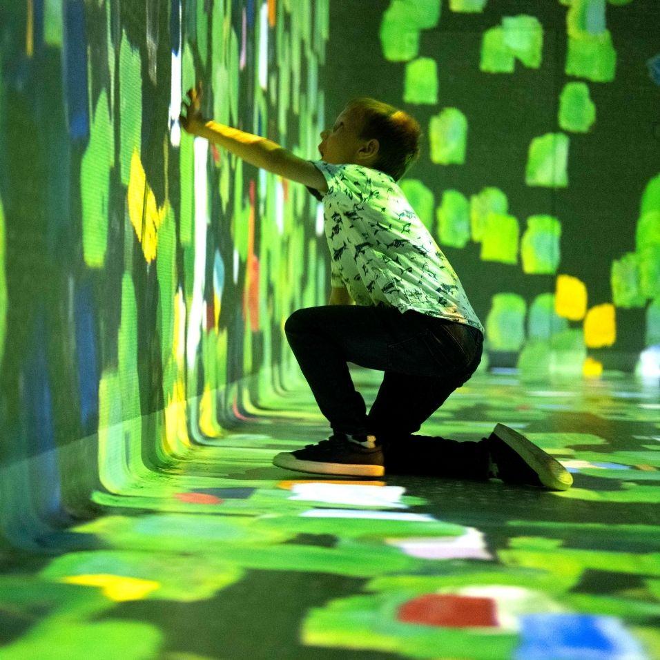 Young visitor interacting with brush strokes in Colour in Motion