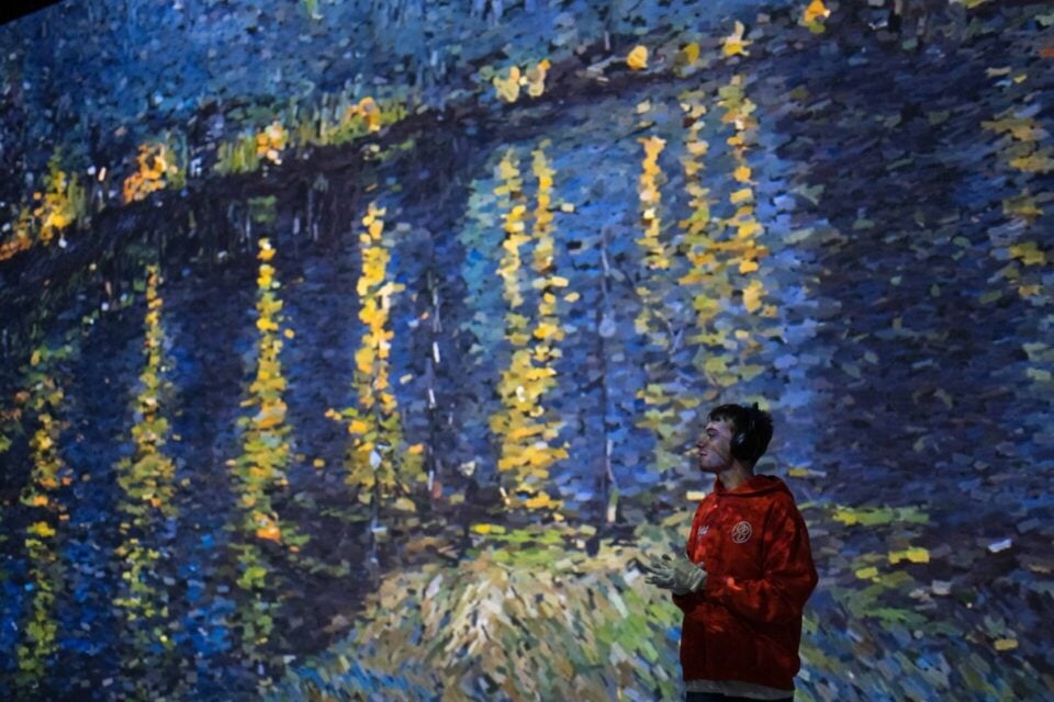 Visitors walking through a Frameless gallery with Van Gogh projections