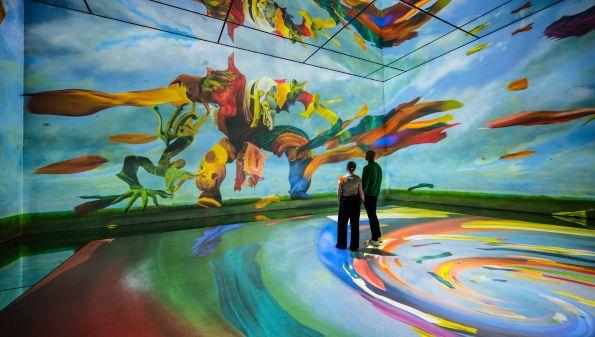 Visitors standing in a colourful Frameless projection room