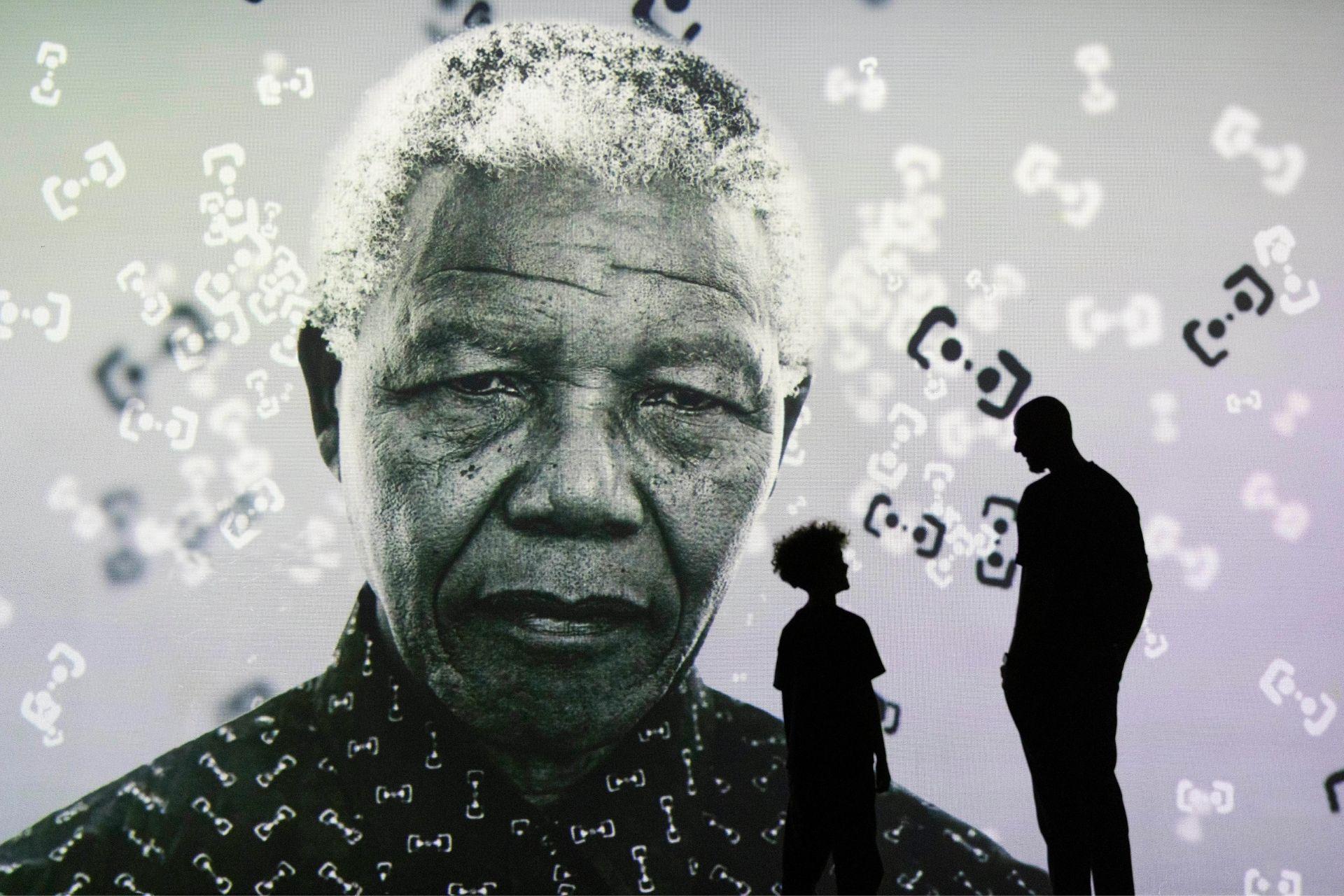 An adult and child viewing a Nelson Mandela portrait at Frameless