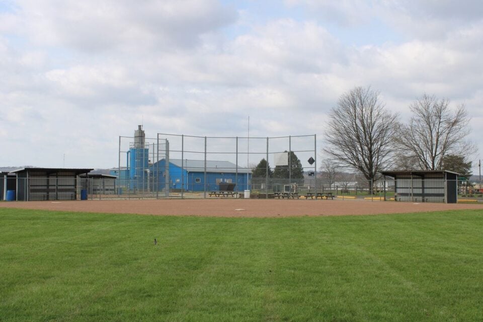 Empty baseball field with dugouts under a cloudy sky