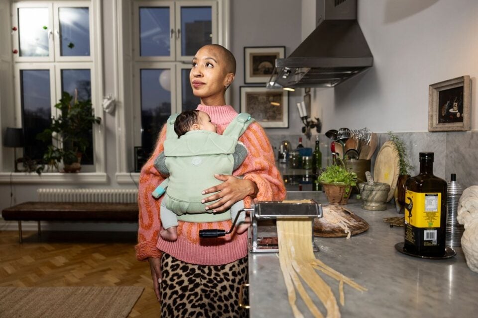 Porte-bébé Najell porté dans une cuisine ouverte