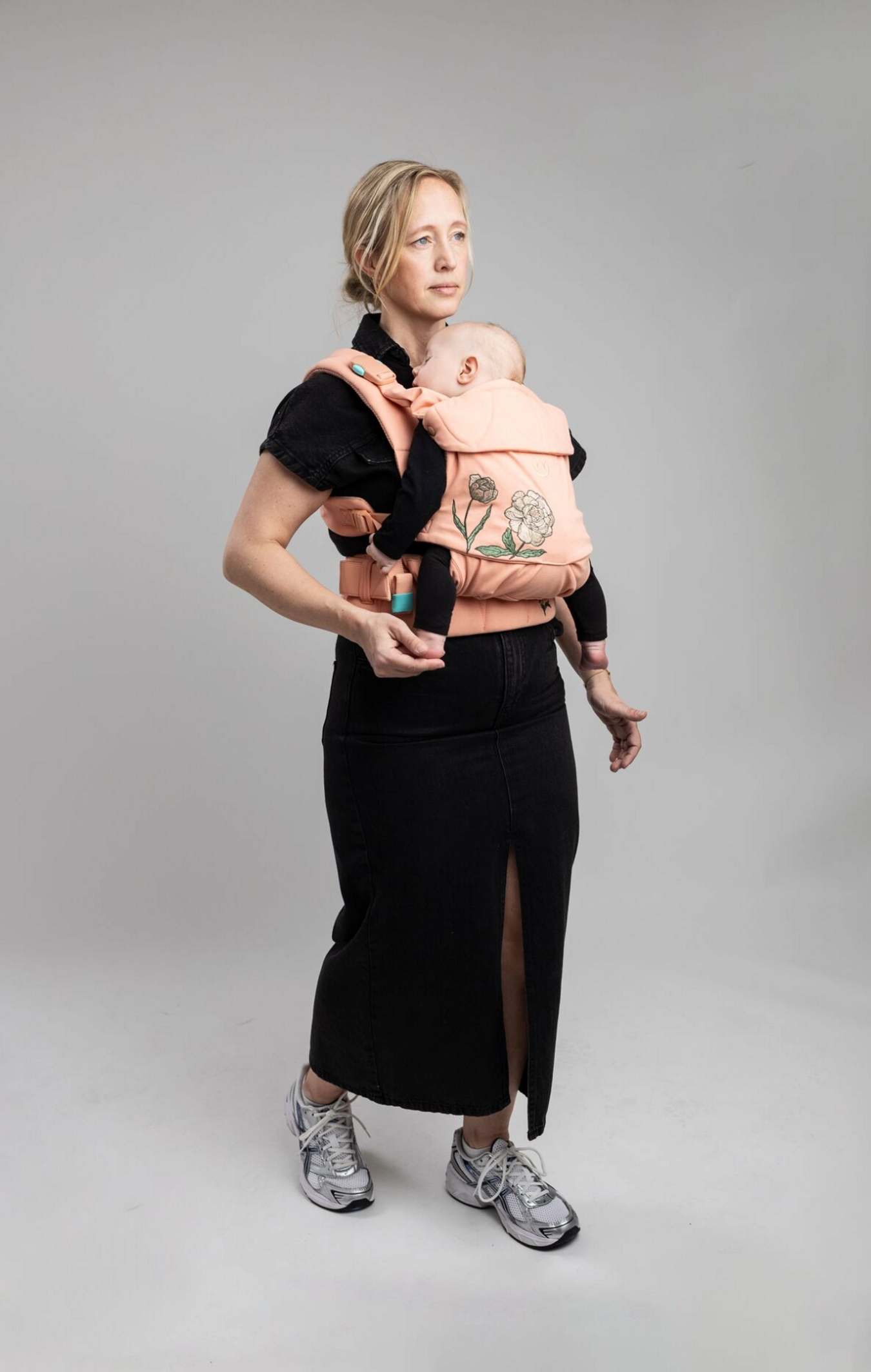 Parent portant un bébé avec un porte-bébé Najell