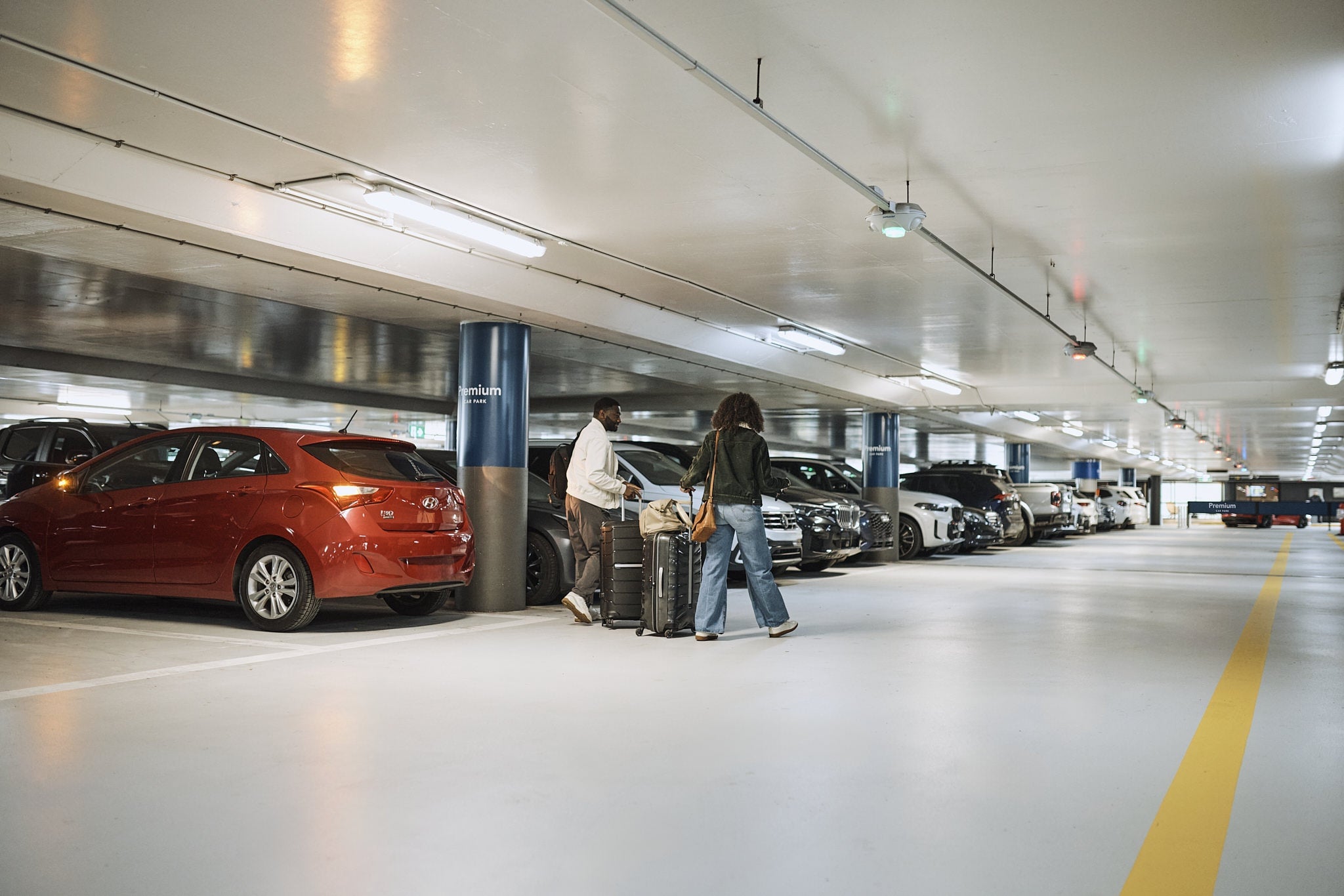 Travellers walking inside an airport parking garage