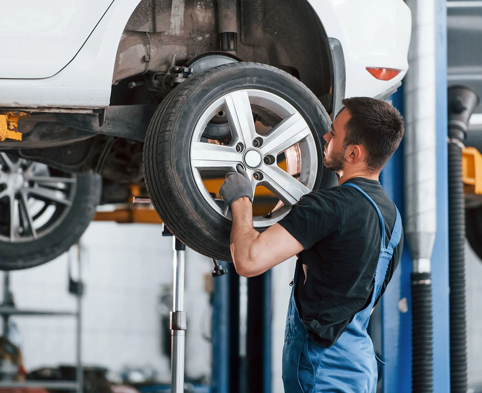 Mechaniker montiert ein Rad in einer professionellen Werkstatt