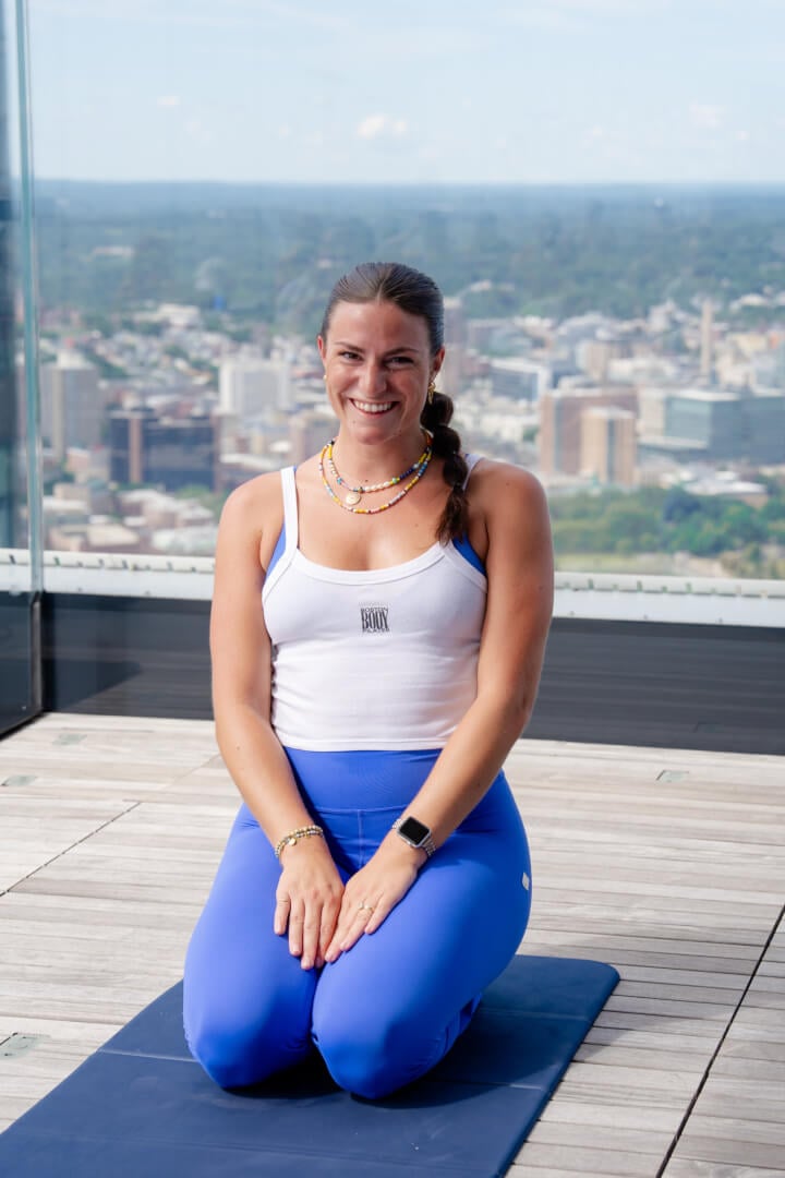 A visitor standing by the panoramic windows with Boston behind her