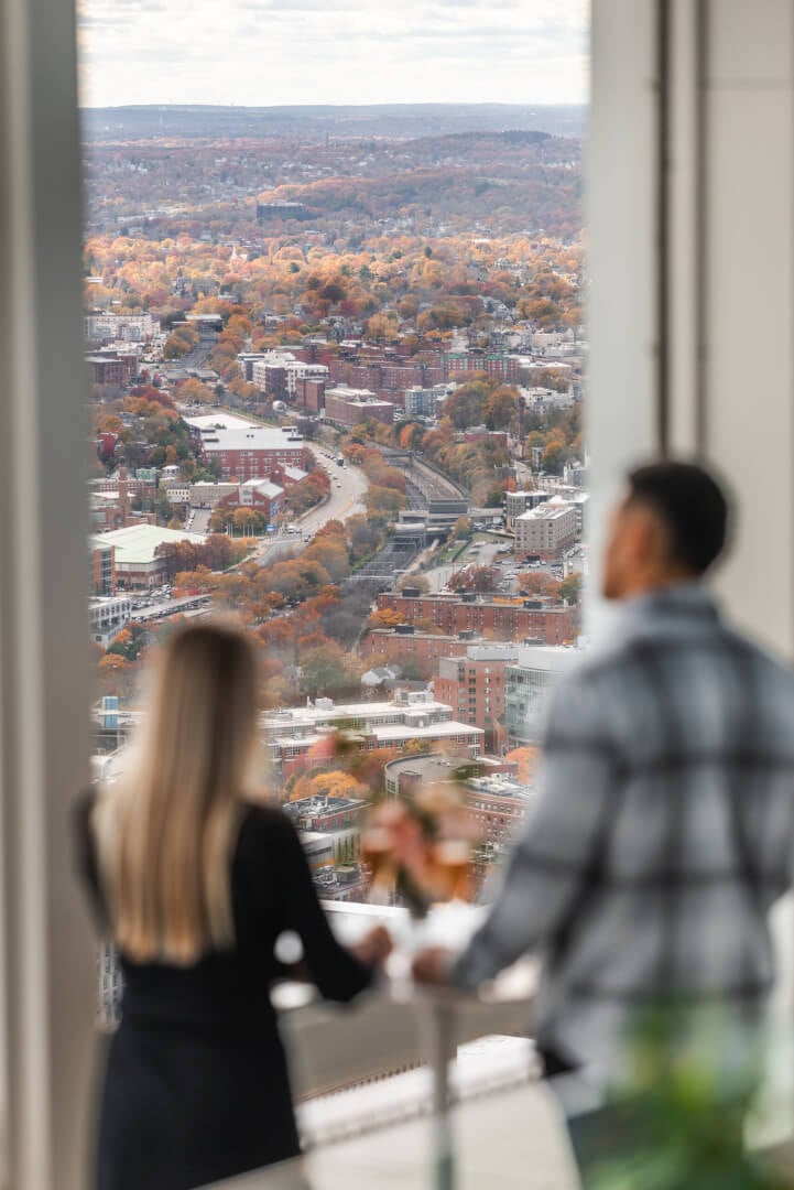 Visitors pausing beside the windows overlooking Boston